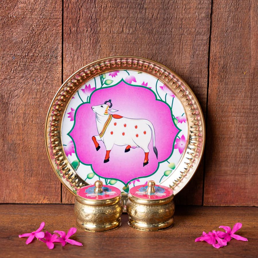 Pichwai-painted brass plate with a sacred cow motif and two engraved kumkum pots