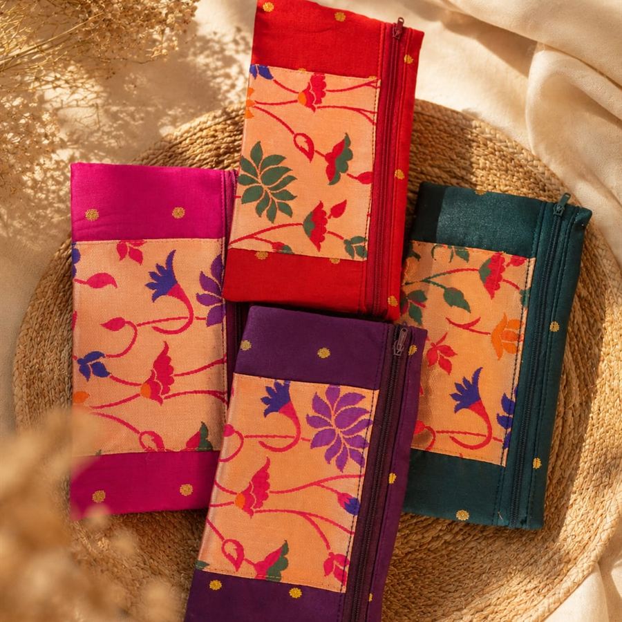 Four silk brocade zip pouches in pink, red, purple and teal with floral weave